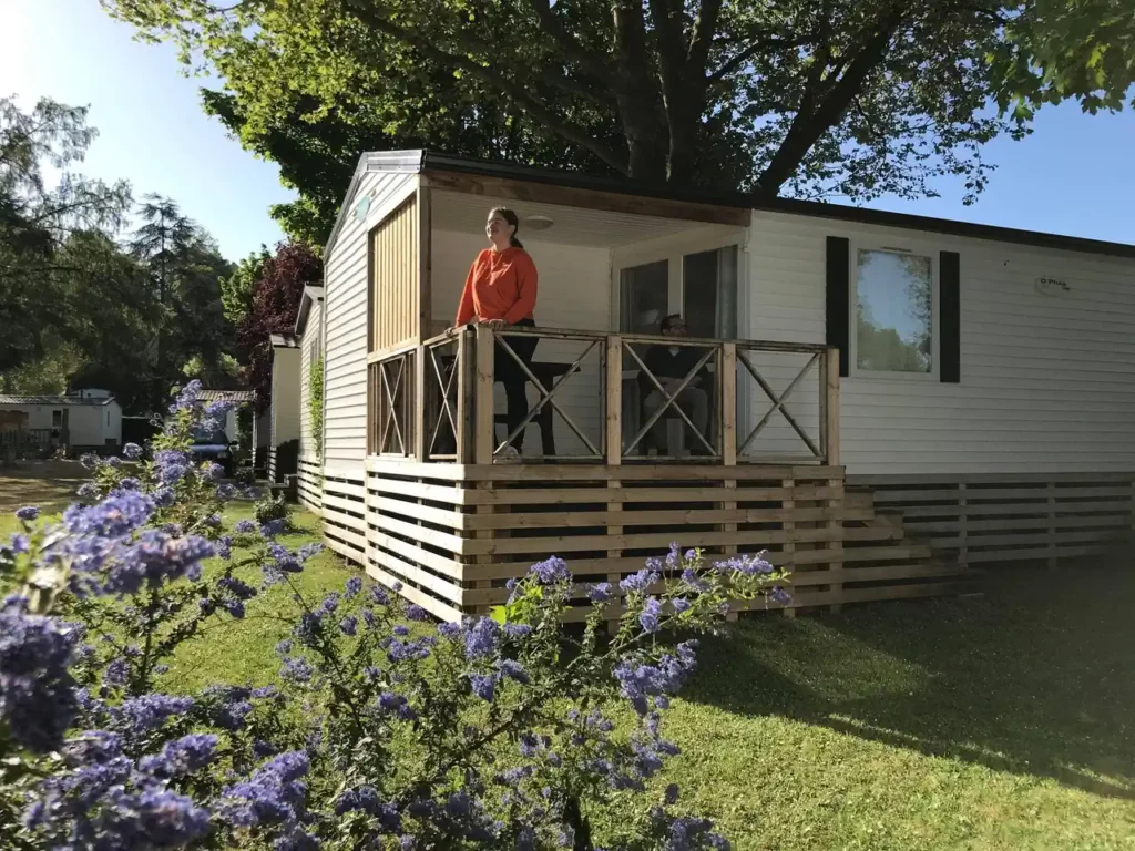 Vrouw die de lucht neemt op het terras van een stacaravan van de camping