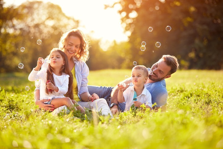 famille heureuse qui joue dans l'herbe