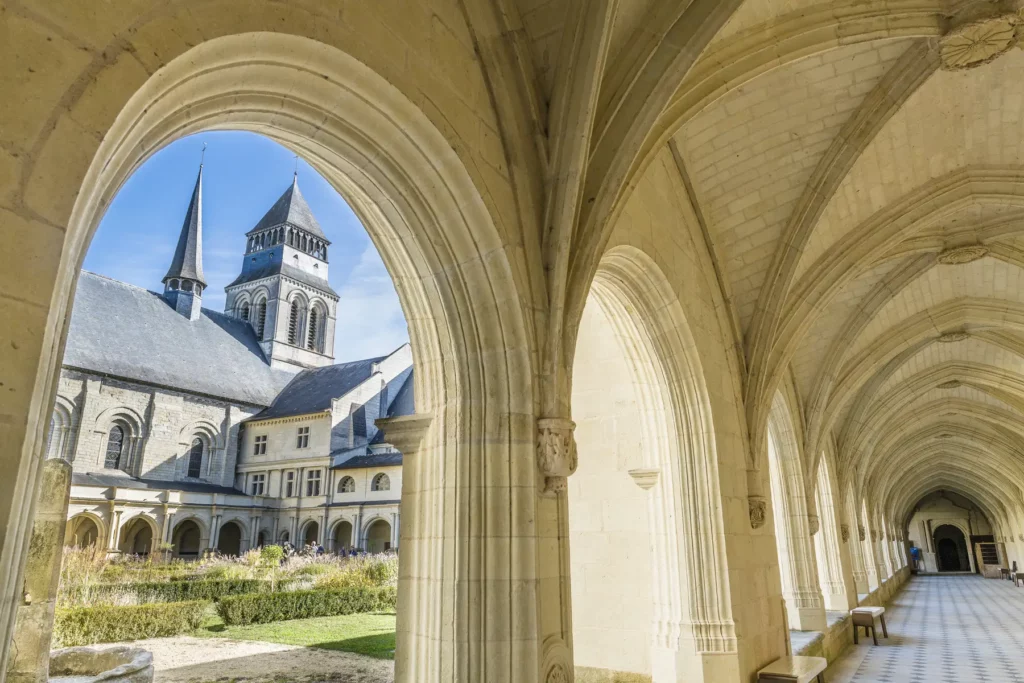 intérieur des arches de l'abbaye de Fontrevaud avec les tours de l'abbaye au second plan en plein soleil