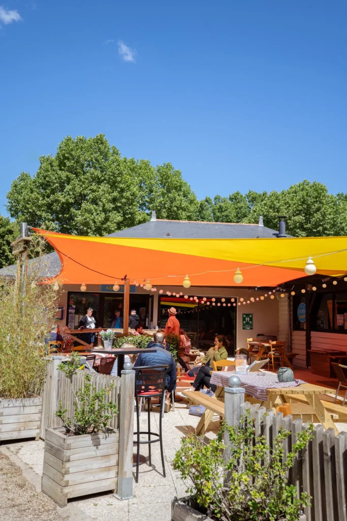 Foto van de guinguette des Nobis met mensen die iets drinken onder de blauwe hemel