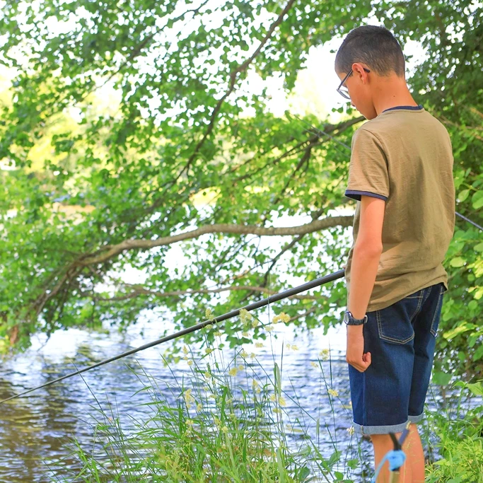 enfant qui pêche en bord de rivière